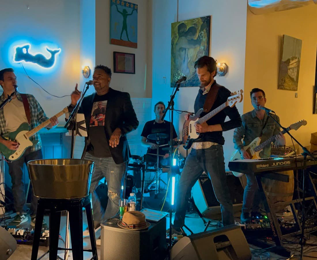 Water Towers performing under a whale neon sign